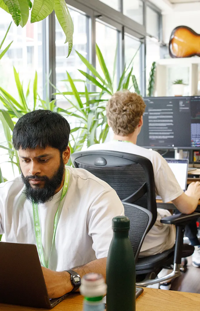 Founders working at desks with 28-inch monitors inside Ramen Space coworking in Dalston