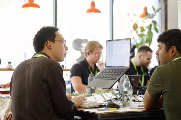 Founders swapping feedback at a desk at Ramen Space