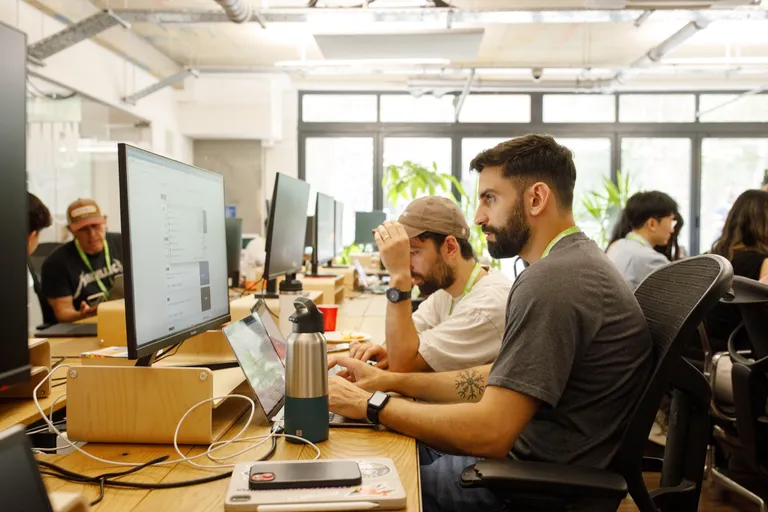 SaaS founders working on 28-inch monitors at Ramen Space