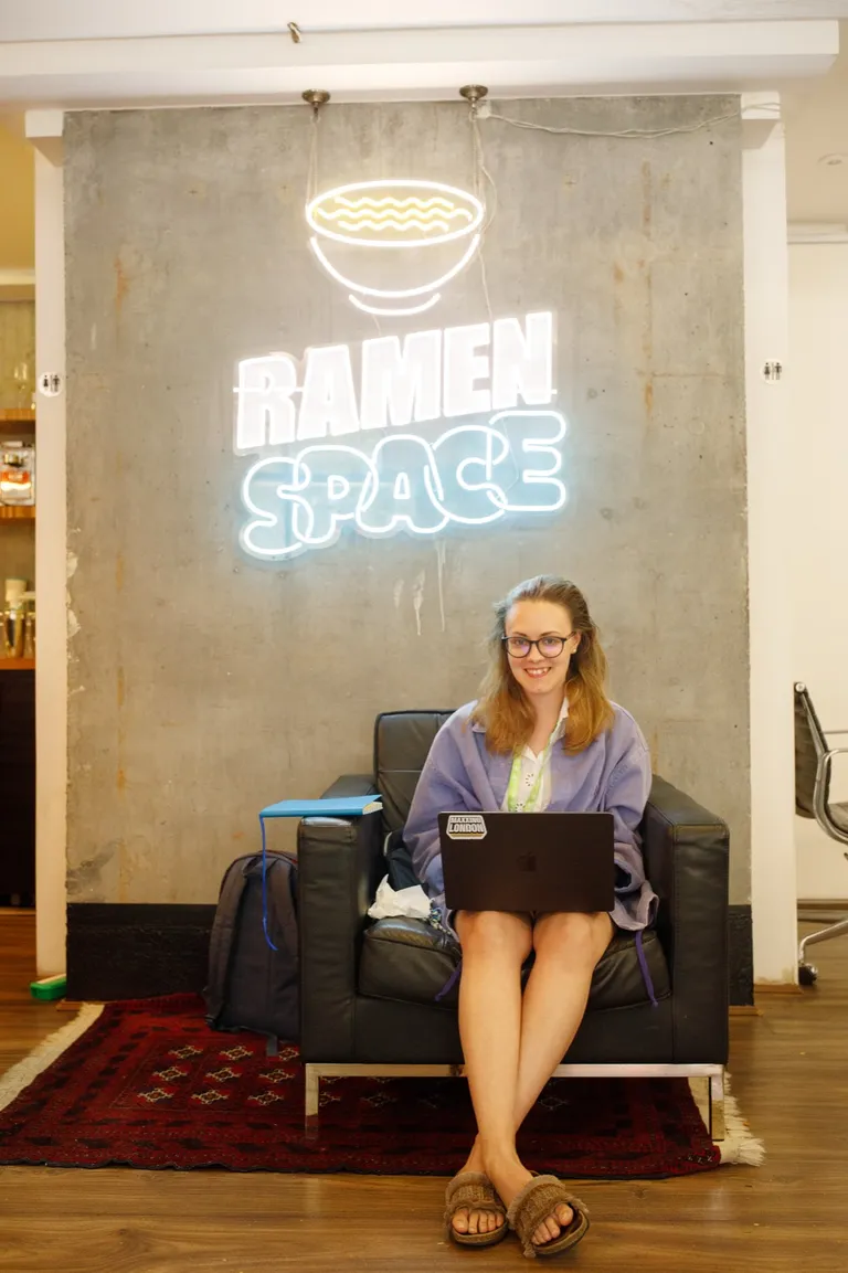 A founder working under the Ramen Space neon sign